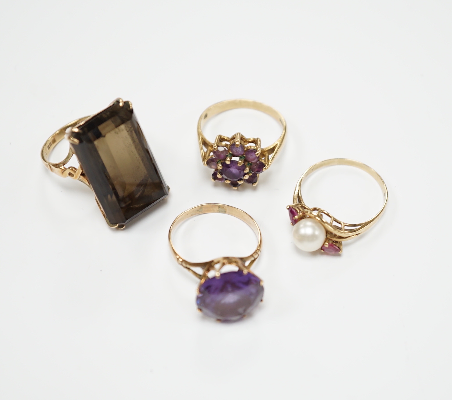 Two modern 9ct gold and gem set dress rings and two other yellow metal and gem set dress rings, gross weight 19.9 grams.